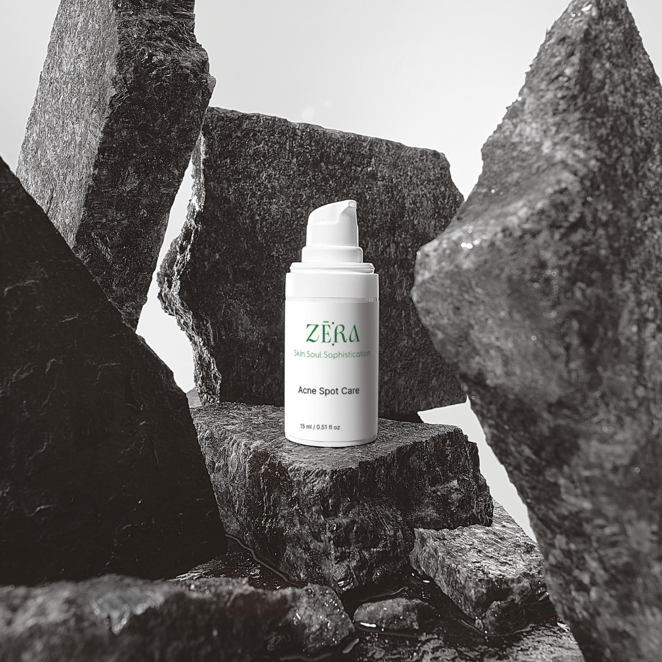 Zera skincare bottle on a rock with a black and white filter