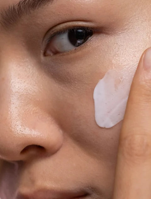 Close-up of a person applying cream to their face