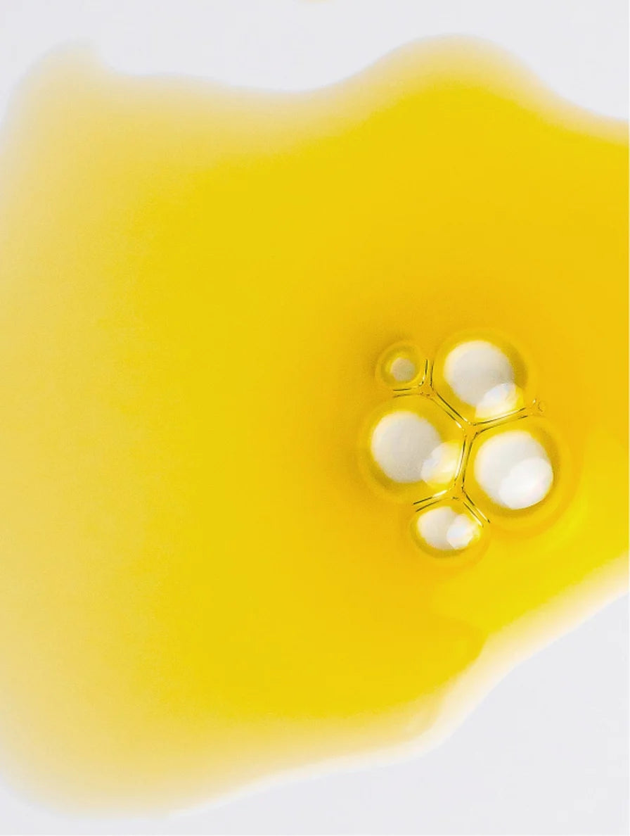 Close-up of a yellow liquid with bubbles on a white background