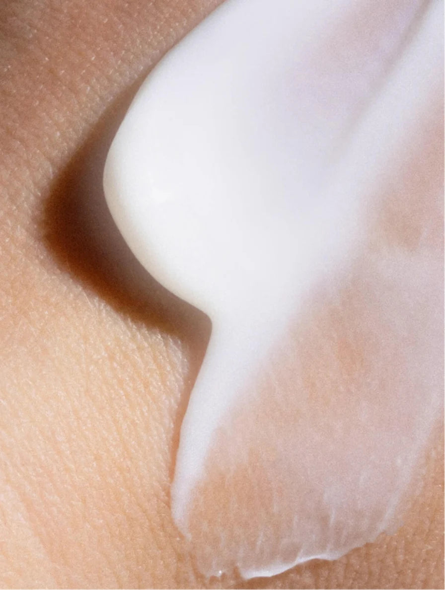 Close-up of a white cream being applied to skin