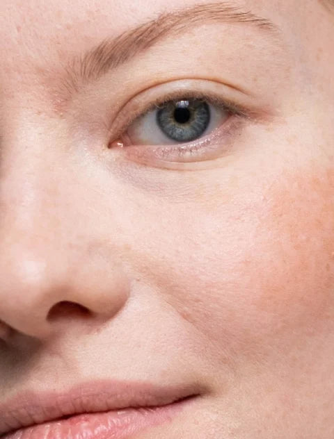 Close-up of a person's eye with blue irises and light brown eyebrows.