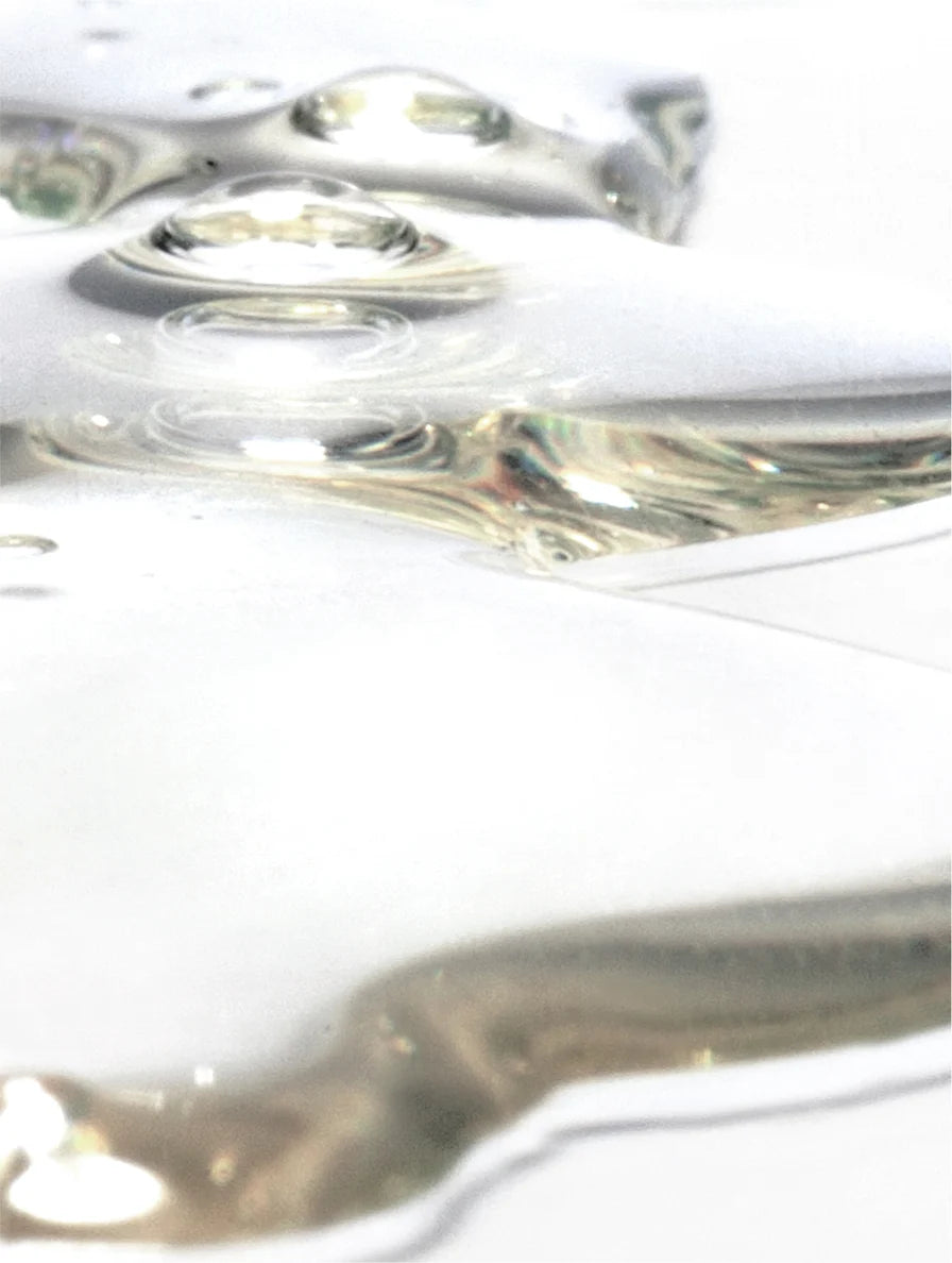 Close-up of clear liquid with ripples on a white background