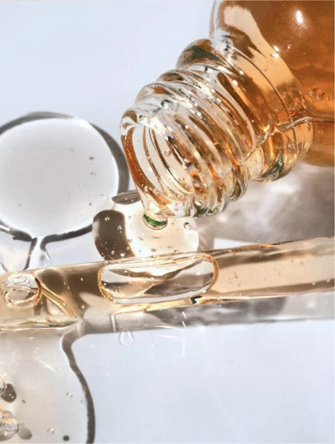 Close-up of a dropper with liquid being dispensed into a clear container.
